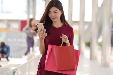 mutlu genç Asyalı kadın ile alışveriş çantası .