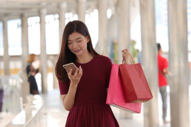 mutlu genç Asyalı kadın ile alışveriş çantası .