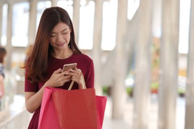 mutlu genç Asyalı kadın ile alışveriş çantası .