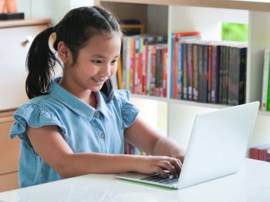 Kütüphane odada dizüstü kullanarak Asain çocuk.