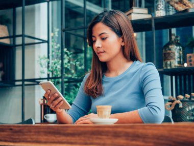 Asyalı kadın kahve dükkanı kafede kahve içme