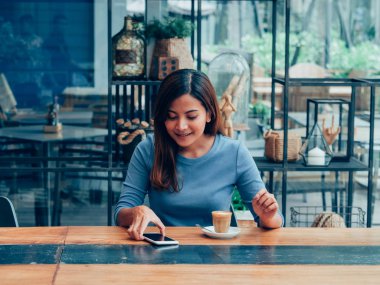 Asyalı kadın kahve dükkanı kafede kahve içme