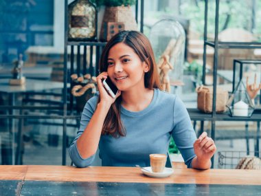 Asyalı kadın kahve dükkanı kafede kahve içme