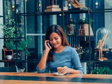 Asyalı kadın kahve dükkanı kafede kahve içme