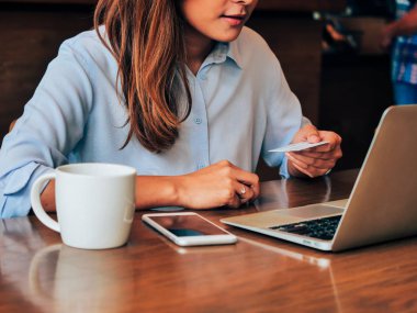Kredi kartı ve kafede dizüstü ile asain kadın eller yukarı kapatın.