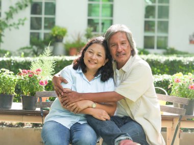 Üst düzey çift birlikte ev bahçesinde gülüyor.