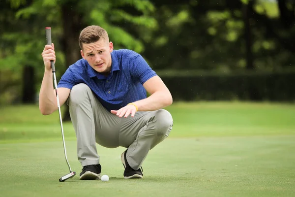 Profressional のゴルファーがグリーンでゴルフを置くための線をチェック — ストック写真