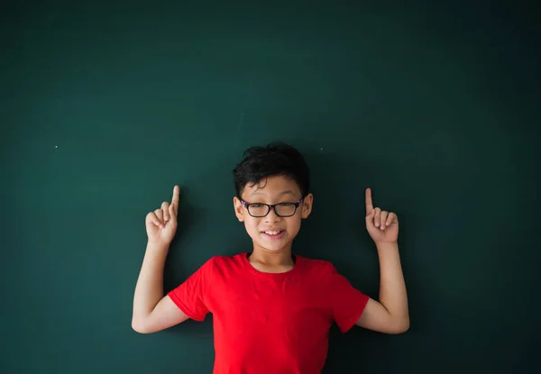 Asian boy with book on blackboard background education school cl — Stock Photo, Image