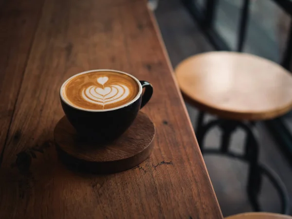 Kaffe latte på trä skrivbordet i café — Stockfoto