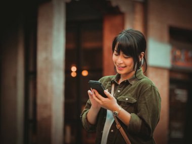 Asyalı kadın alışveriş merkezi mutlu ruh hali ile Smartphone kullanarak
