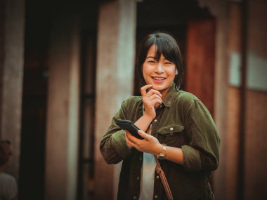 Asyalı kadın alışveriş merkezi mutlu ruh hali ile Smartphone kullanarak