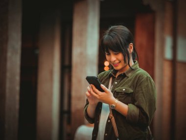 Asyalı kadın alışveriş merkezi mutlu ruh hali ile Smartphone kullanarak
