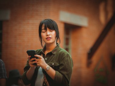 Asyalı kadın alışveriş merkezi mutlu ruh hali ile Smartphone kullanarak