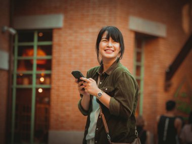 Asyalı kadın alışveriş merkezi mutlu ruh hali ile Smartphone kullanarak