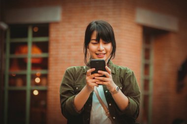 Asyalı kadın alışveriş merkezi mutlu ruh hali ile Smartphone kullanarak