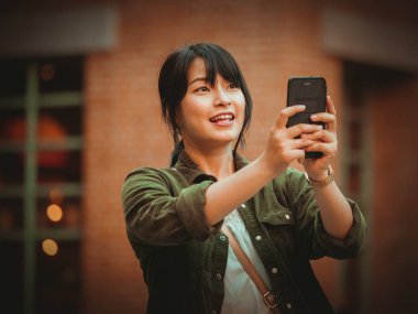 Asyalı kadın alışveriş merkezi mutlu ruh hali ile Smartphone kullanarak