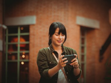 Asyalı kadın alışveriş merkezi mutlu ruh hali ile Smartphone kullanarak
