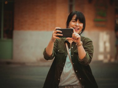 Asyalı kadın alışveriş merkezi mutlu ruh hali ile Smartphone kullanarak