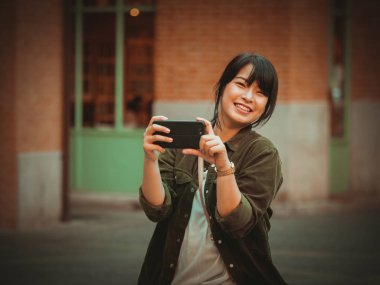 Asyalı kadın alışveriş merkezi mutlu ruh hali ile Smartphone kullanarak