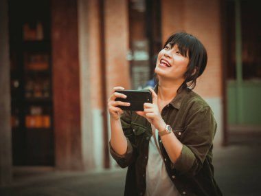 Asyalı kadın alışveriş merkezi mutlu ruh hali ile Smartphone kullanarak