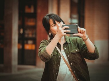 Asyalı kadın alışveriş merkezi mutlu ruh hali ile Smartphone kullanarak