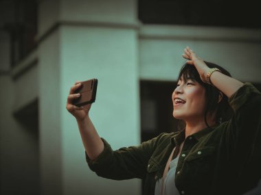 Asyalı kadın alışveriş merkezi mutlu ruh hali ile Smartphone kullanarak