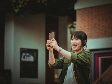 Asyalı kadın alışveriş merkezi mutlu ruh hali ile Smartphone kullanarak