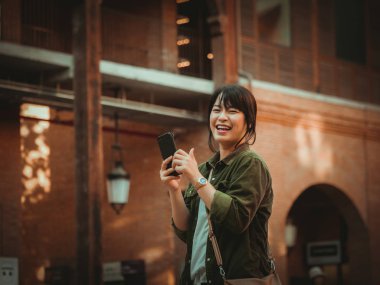Asyalı kadın alışveriş merkezi mutlu ruh hali ile Smartphone kullanarak
