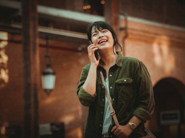 Asyalı kadın alışveriş merkezi mutlu ruh hali ile Smartphone kullanarak