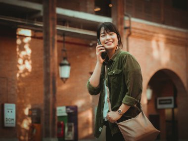 Asyalı kadın alışveriş merkezi mutlu ruh hali ile Smartphone kullanarak