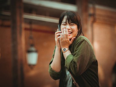 Asyalı kadın alışveriş merkezi mutlu ruh hali ile Smartphone kullanarak