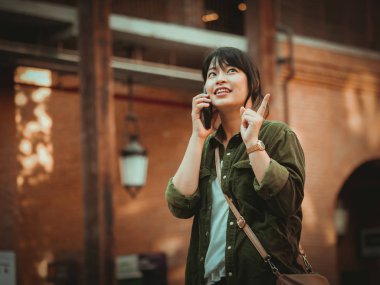 Asyalı kadın alışveriş merkezi mutlu ruh hali ile Smartphone kullanarak