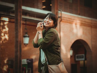 Asyalı kadın alışveriş merkezi mutlu ruh hali ile Smartphone kullanarak