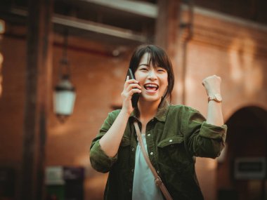 Asyalı kadın alışveriş merkezi mutlu ruh hali ile Smartphone kullanarak