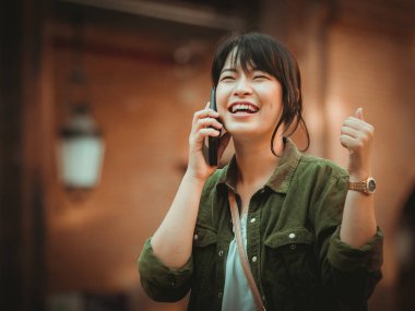 Asyalı kadın alışveriş merkezi mutlu ruh hali ile Smartphone kullanarak