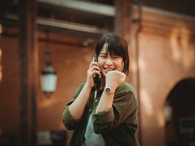 Asyalı kadın alışveriş merkezi mutlu ruh hali ile Smartphone kullanarak