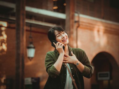 Asyalı kadın alışveriş merkezi mutlu ruh hali ile Smartphone kullanarak