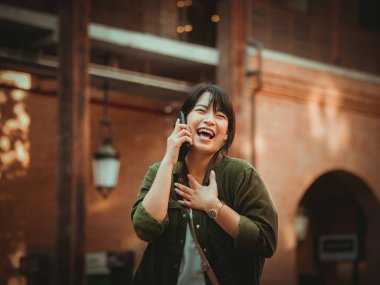 Asyalı kadın alışveriş merkezi mutlu ruh hali ile Smartphone kullanarak