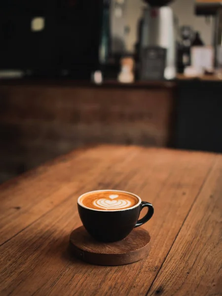 Kaffe latte på trä skrivbordet i café — Stockfoto