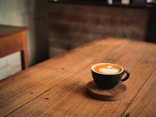 Káva latte na dřevěný stůl v café — Stock fotografie