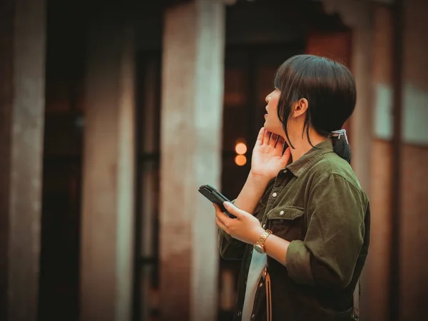 Mujer asiática usando smartphone con estado de ánimo feliz en el centro comercial — Foto de Stock