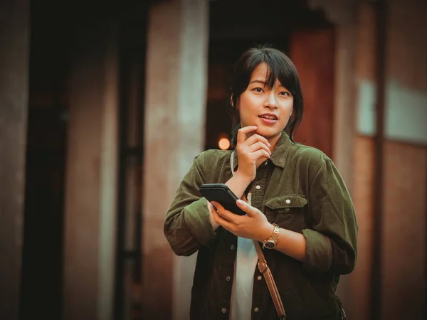 Asian woman using smartphone with happy mood in shopping mall — Stock Photo, Image