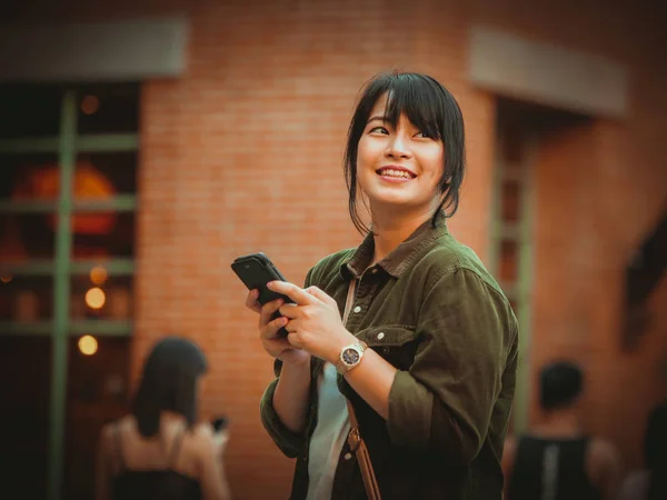 Mujer asiática usando smartphone con estado de ánimo feliz en el centro comercial — Foto de Stock