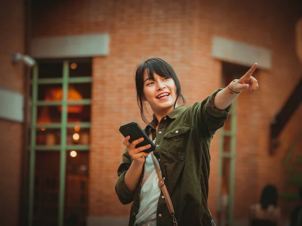 Mujer asiática usando smartphone con estado de ánimo feliz en el centro comercial — Foto de Stock