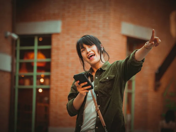 Mulher asiática usando smartphone com humor feliz no shopping — Fotografia de Stock