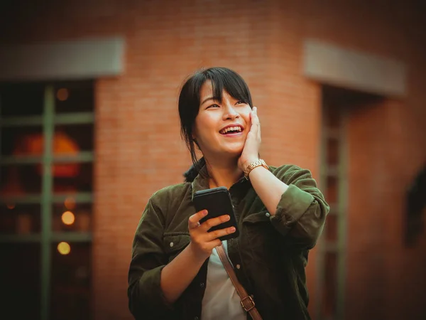 Mulher asiática usando smartphone com humor feliz no shopping — Fotografia de Stock