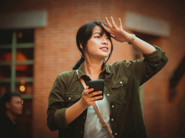 Mulher asiática usando smartphone com humor feliz no shopping — Fotografia de Stock