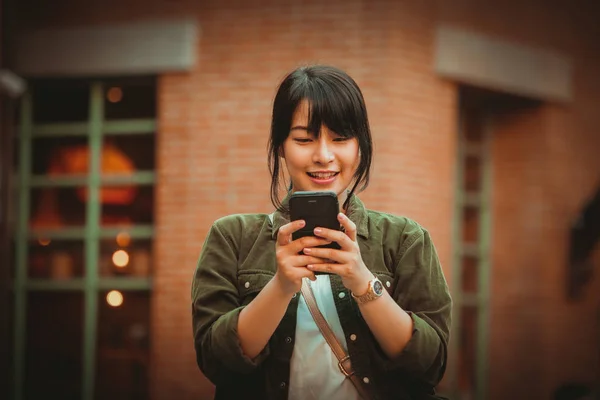 Aziatische vrouw smartphone met gelukkige stemming in winkelcentrum — Stockfoto