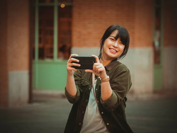 Mulher asiática usando smartphone com humor feliz no shopping — Fotografia de Stock