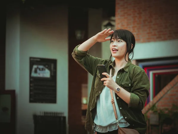 Азіатський жінка за допомогою смартфона з радісний настрій в торговий центр — стокове фото